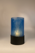 Teelichthalter mit blauem Epoxidharz-Zylinder und schwarzer PLA-Basis vor neutralem Hintergrund